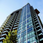 Beacon tower, a project part of the Seylynn Village development, can be seen towering towards a bright blue sky with some greenery near the bottom.